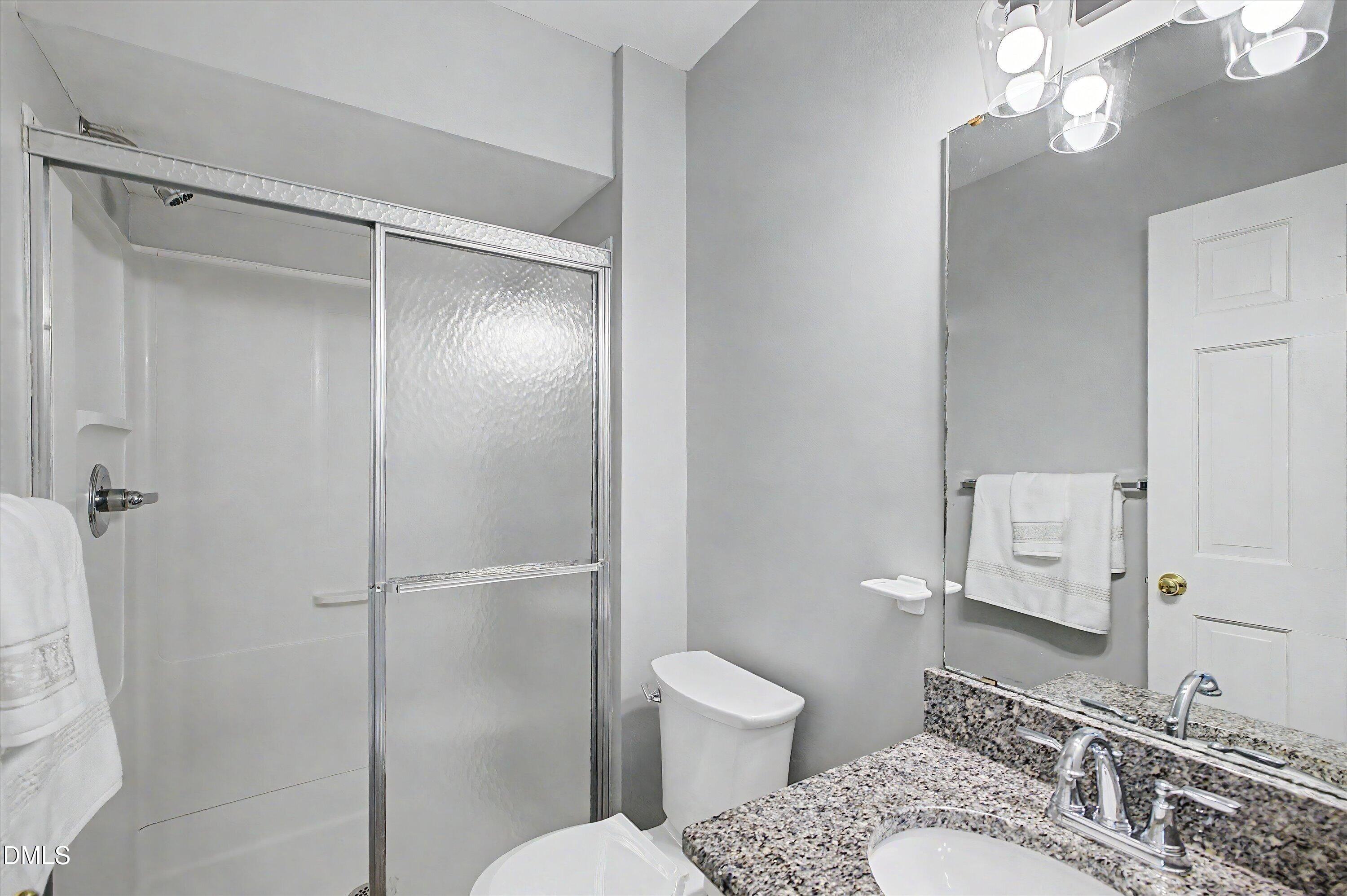 5519 Hamstead Crossing Raleigh, NC 27612 - Photo 22 of 33 a bathroom with a granite countertop sink toilet and shower