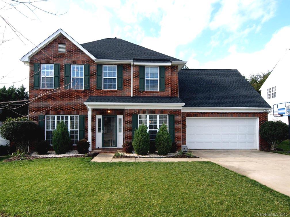 a front view of a house with yard and green space