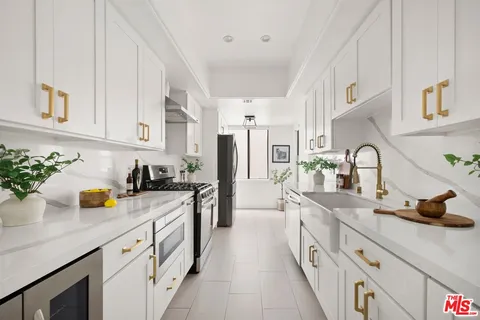 a kitchen with stainless steel appliances a sink a stove and cabinets