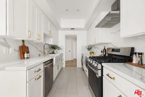 a kitchen with stainless steel appliances a sink stove and cabinets