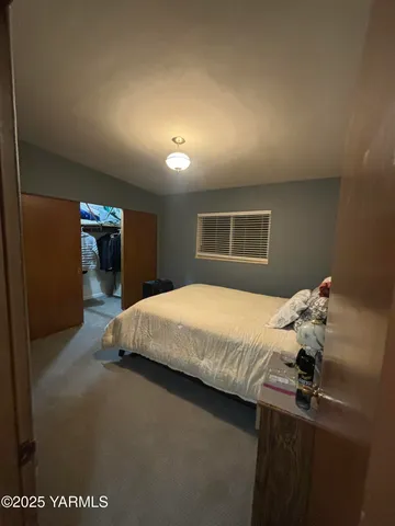 a bedroom with a bed and a large window