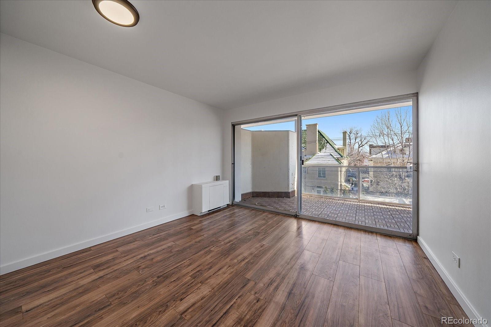 888 Logan Street, Unit 4F Denver, CO 80203 - Photo 11 of 21 a view of empty room with wooden floor and fan