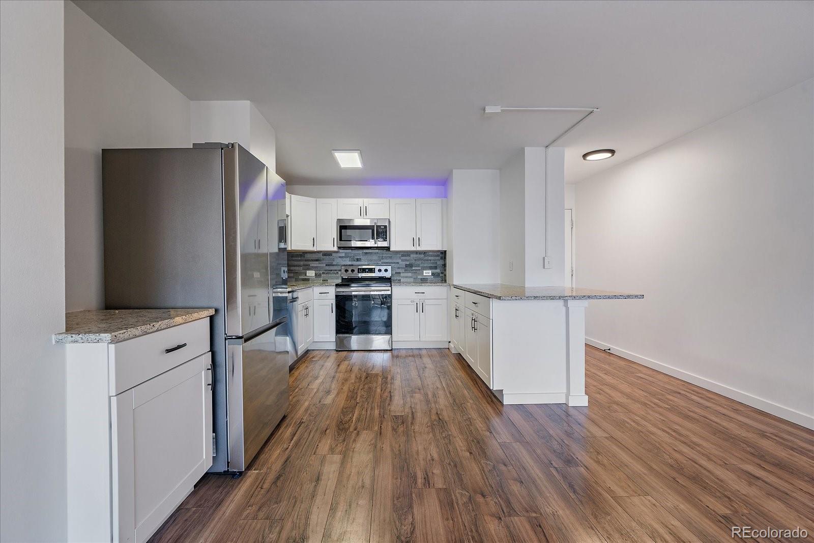 888 Logan Street, Unit 4F Denver, CO 80203 - Photo 8 of 21 a kitchen with wooden floors appliances and wooden floor