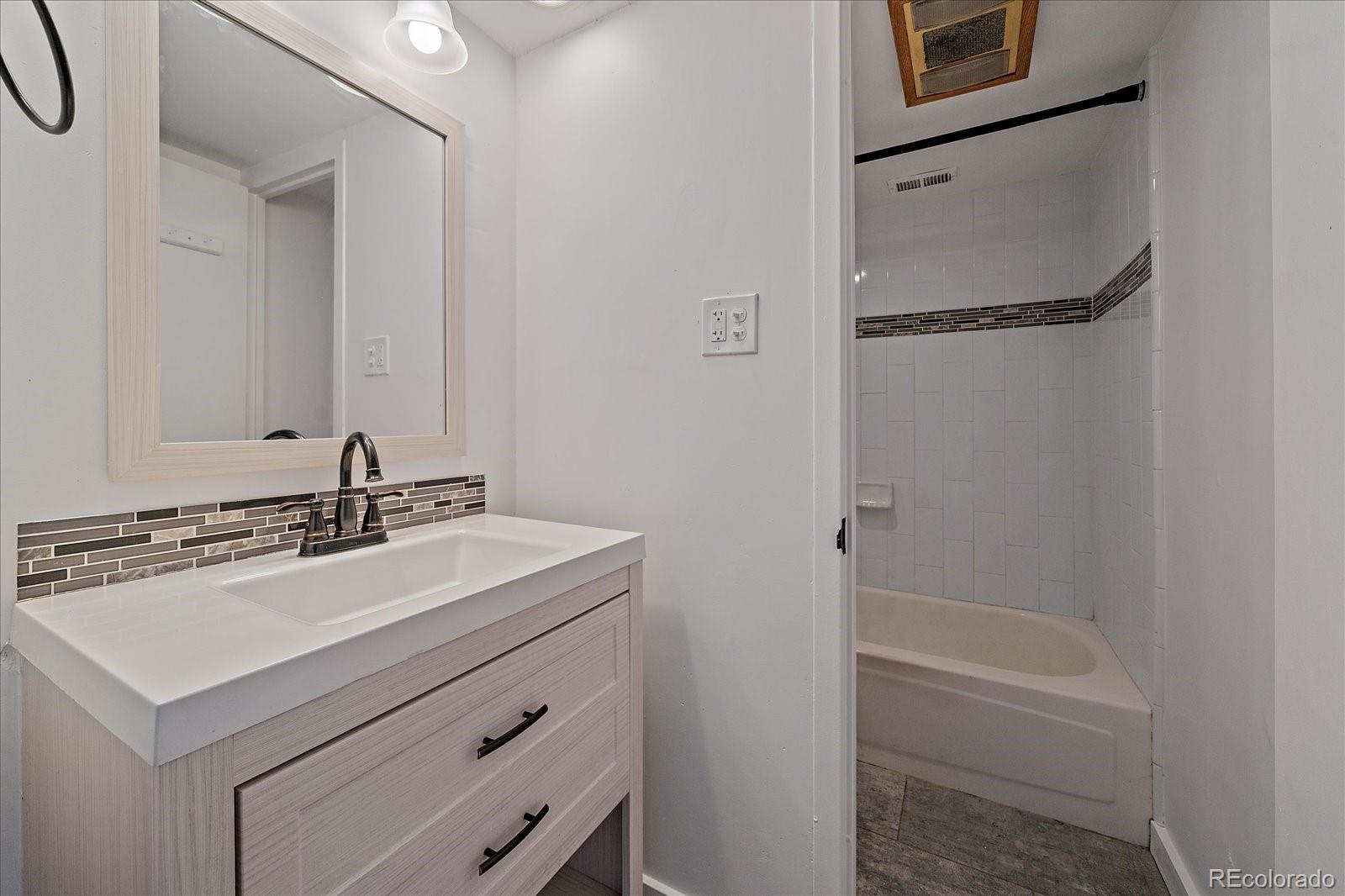 888 Logan Street, Unit 4F Denver, CO 80203 - Photo 10 of 21 a bathroom with a sink a mirror a vanity and a bathtub
