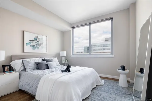 a bedroom with a bed and a large window with outer view