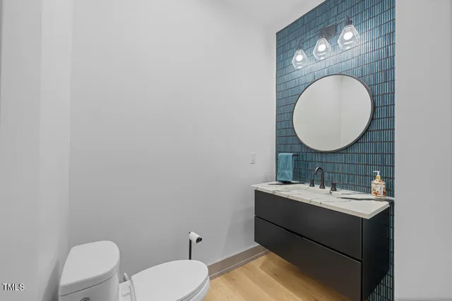 a bathroom with a toilet sink vanity and mirror