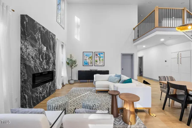 a living room with furniture a fireplace and a chandelier