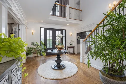 a kitchen with stainless steel appliances granite countertop a stove top oven a sink a refrigerator and white cabinets