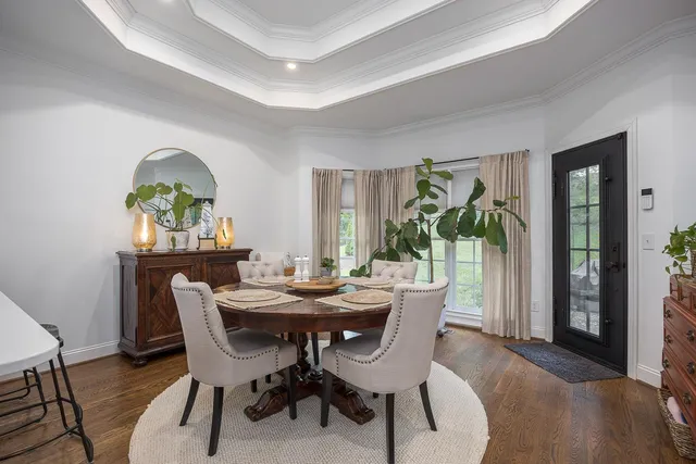 a view of a dining room with furniture a kitchen and wooden floor