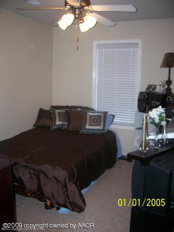 4512 Steffi Court Amarillo, TX 79110 - Photo 4 of 9 a bedroom with a bed and a chandelier