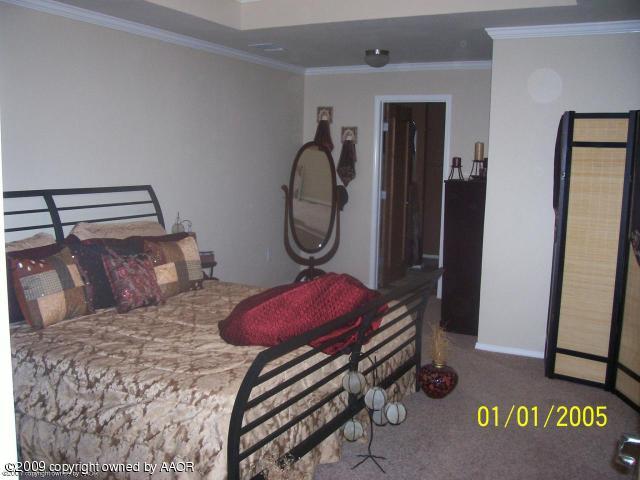 4512 Steffi Court Amarillo, TX 79110 - Photo 6 of 9 a bedroom with a bed and a mirror