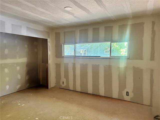 a view of an empty room with wooden floor and windows