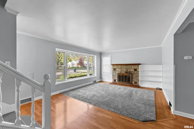a view of an empty room with a fireplace and a window