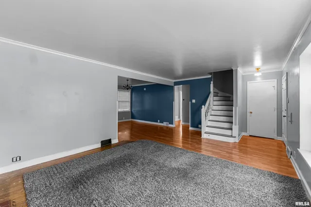 an empty room with wooden floor and entryway