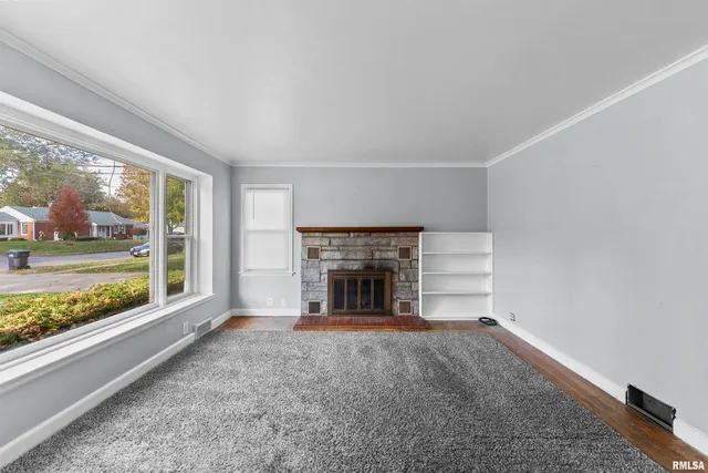 a view of an empty room with a fireplace and a window