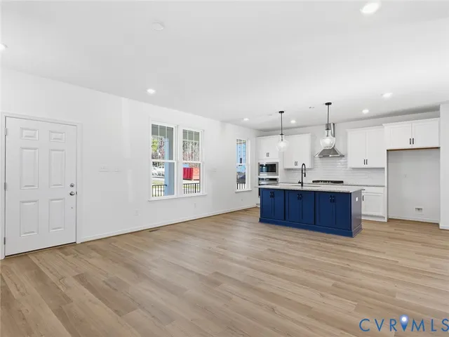a kitchen with stainless steel appliances kitchen island wooden cabinets and entryway