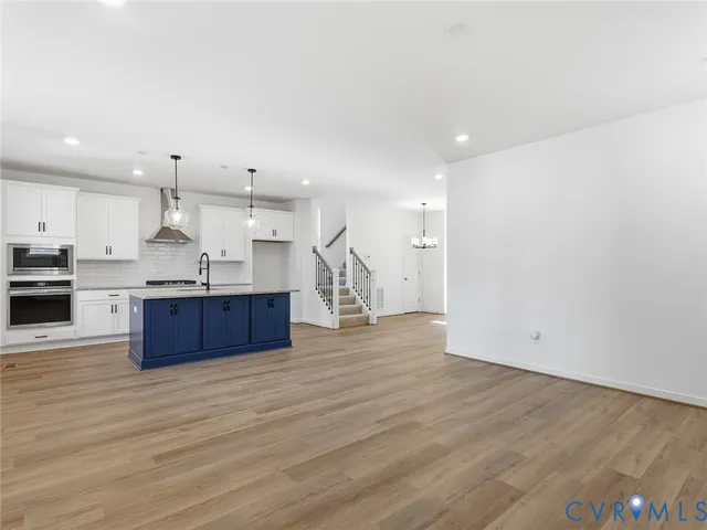 a kitchen with stainless steel appliances kitchen island a cabinets and wooden floor