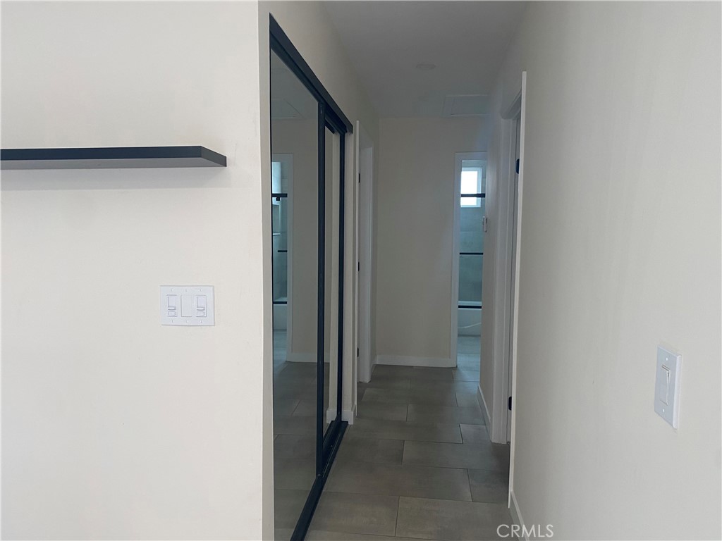 5591 Vallecito Avenue Westminster, CA 92683 - Photo 35 of 37 a view of a hallway with wooden shelves