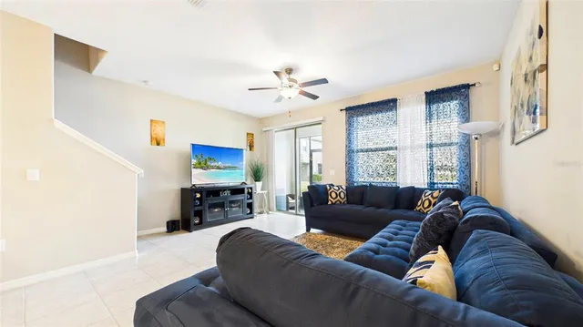 a living room with furniture ceiling fan and a window