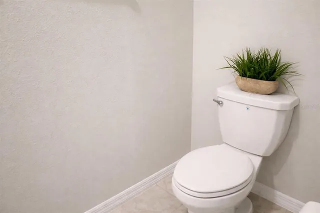 a white toilet sitting next to a white wall