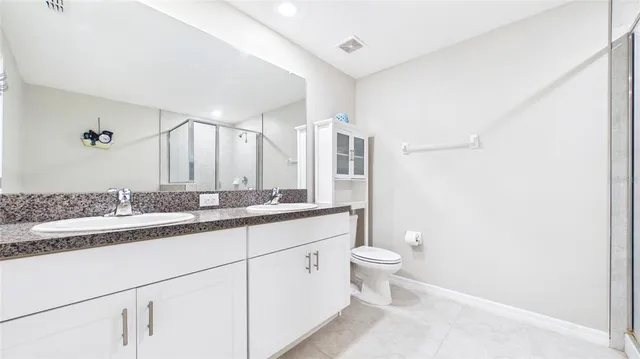 a bathroom with a granite countertop sink a toilet and a mirror