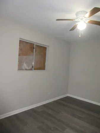 a view of a small space with wooden floor and fan