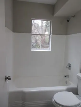 a bathroom with a toilet and a bath tub