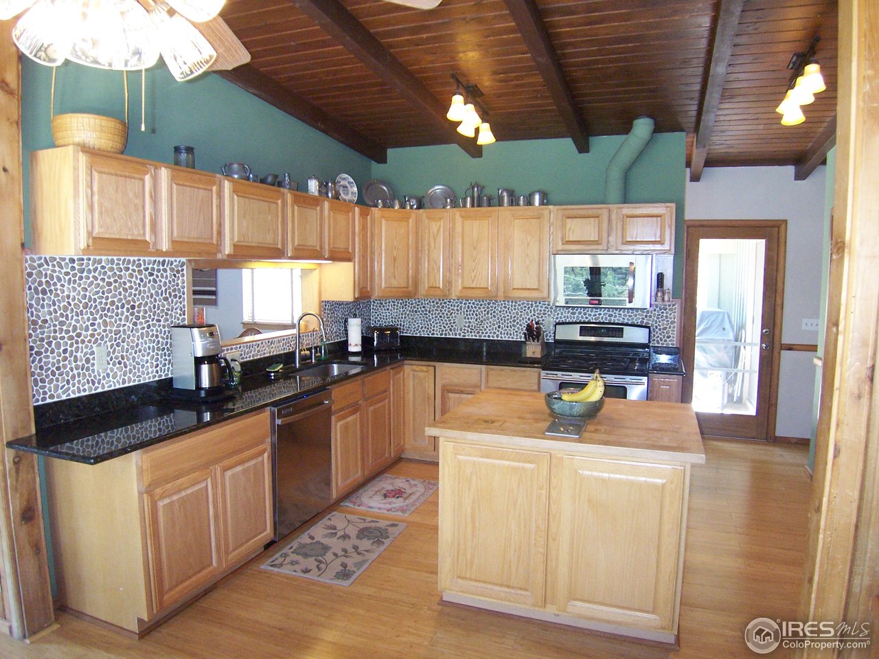 6419 Olde Stage Road Boulder, CO 80302 - Photo 7 of 21 a kitchen with stainless steel appliances kitchen island granite countertop a sink a counter space cabinets and furniture