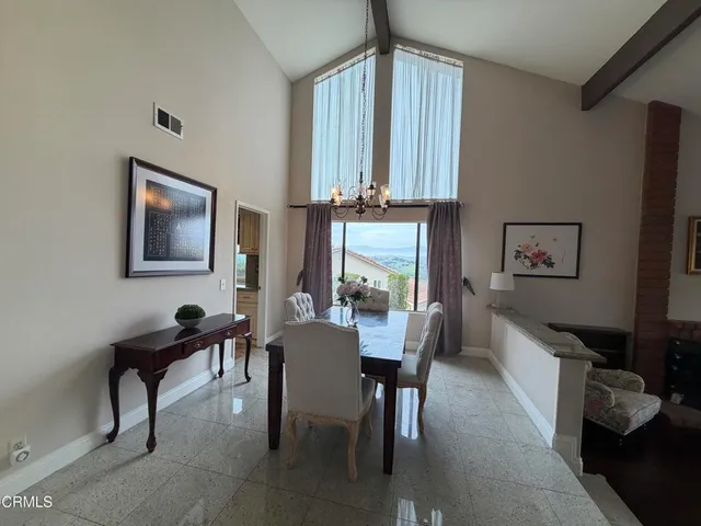 a kitchen with a dining table chairs and refrigerator