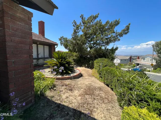 a view of a house with a yard and a garden