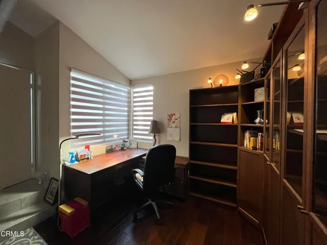 a view of a patio with couches and table and chairs under an umbrella