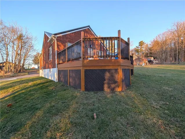 a view of a house with a yard and a deck