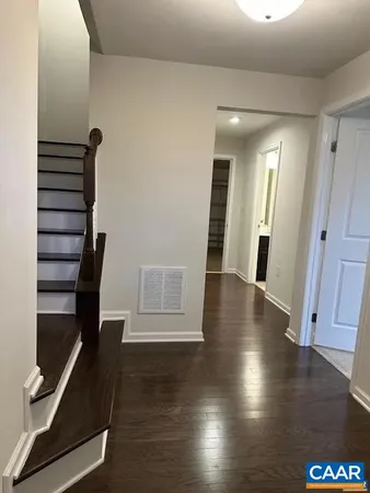 a view of a hallway with wooden floor and stairs
