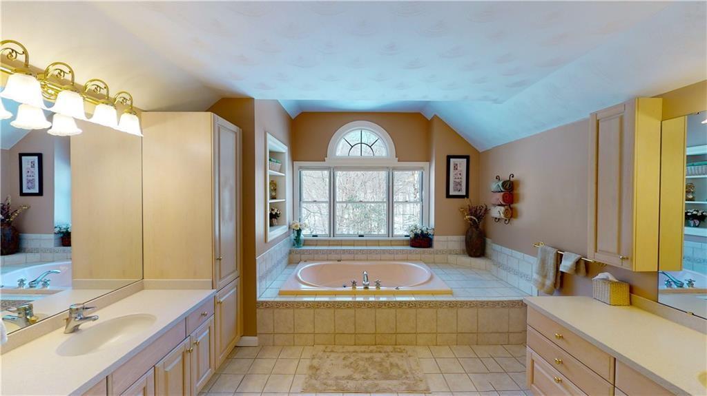 8271 Prindle Road Erie, PA 16510 - Photo 16 of 25 a spacious bathroom with a tub sink and mirror