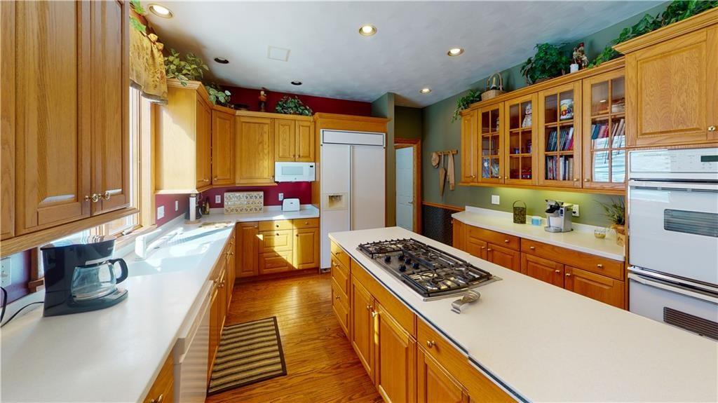 8271 Prindle Road Erie, PA 16510 - Photo 6 of 25 a kitchen with stainless steel appliances granite countertop a stove a sink dishwasher and cabinets with wooden floor