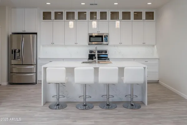 a kitchen with stainless steel appliances granite countertop a stove a sink and a refrigerator