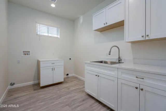 a kitchen with a sink cabinets and wooden floor