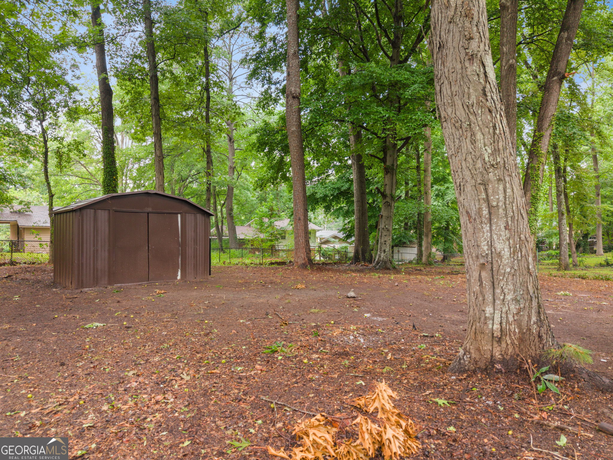 3567 Forrest Park Road Southeast Atlanta, GA 30354 - Photo 23 of 29 a view of a backyard with large trees and a small barn