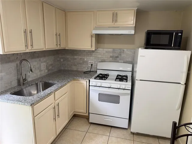 a kitchen with appliances a sink and cabinets