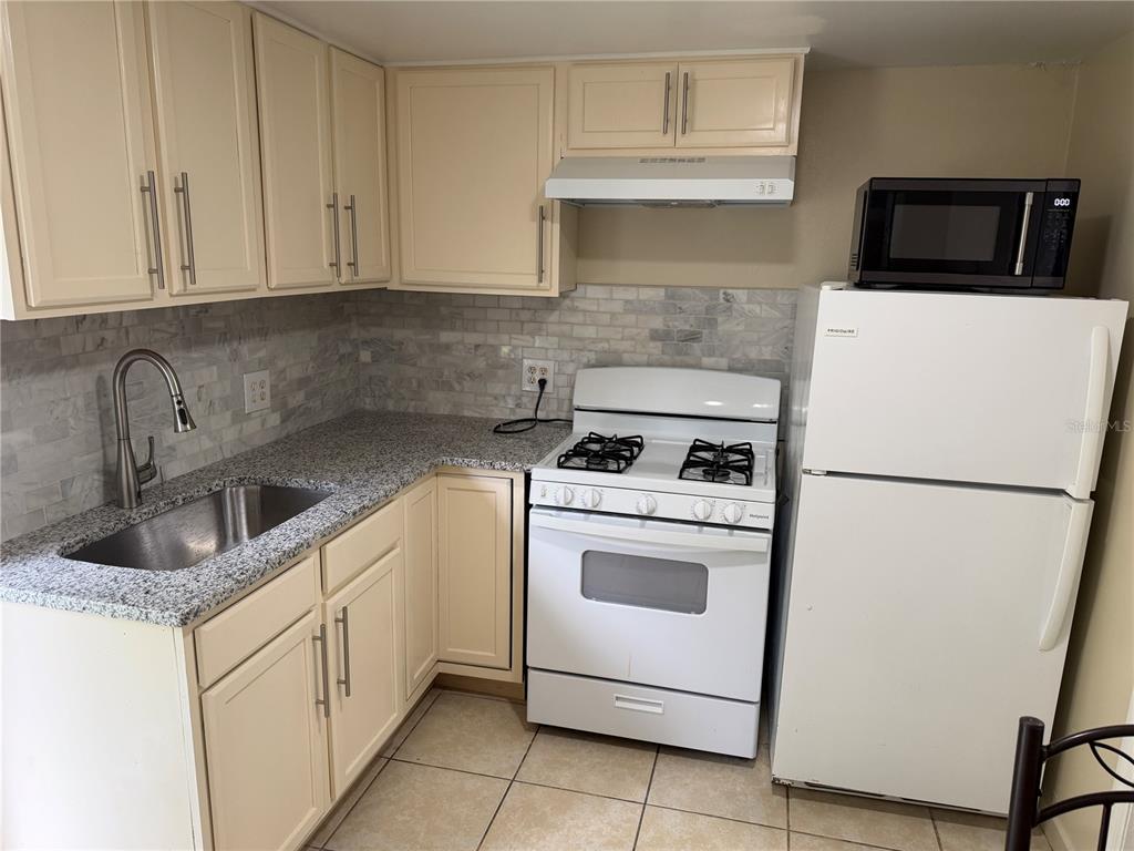 613 Carol Terrace, Unit 2 Kissimmee, FL 34744 - Photo 3 of 7 a kitchen with appliances a sink and cabinets
