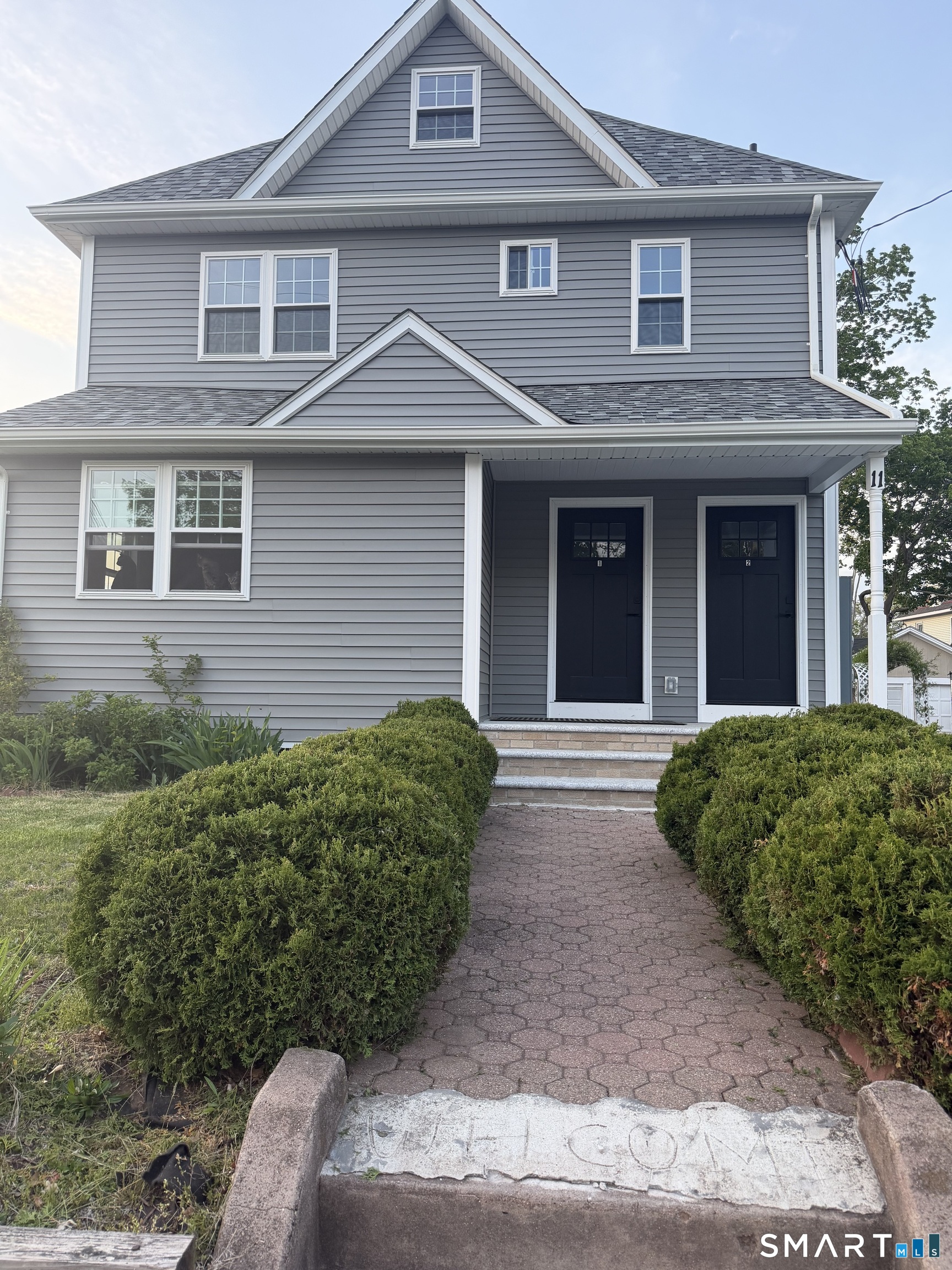 a front view of a house with a garden