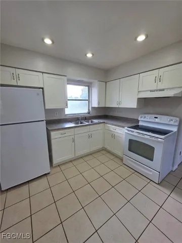 a kitchen with a stove sink and a refrigerator