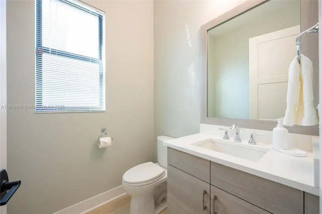 a bathroom with a granite countertop sink a toilet and a mirror