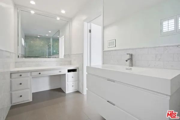 a bathroom with a sink vanity and mirror