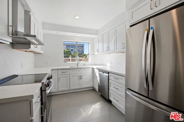 a kitchen with a refrigerator sink and white cabinets