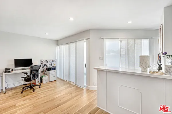 a view of a workspace with furniture and a window