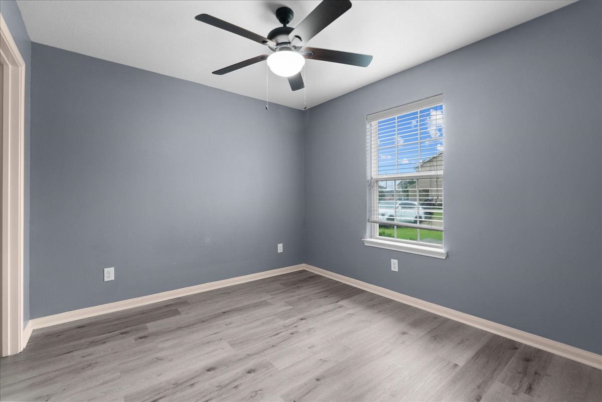 5727 Treasure Cove Road Cove, TX 77523 - Photo 8 of 20 an empty room with wooden floor and windows