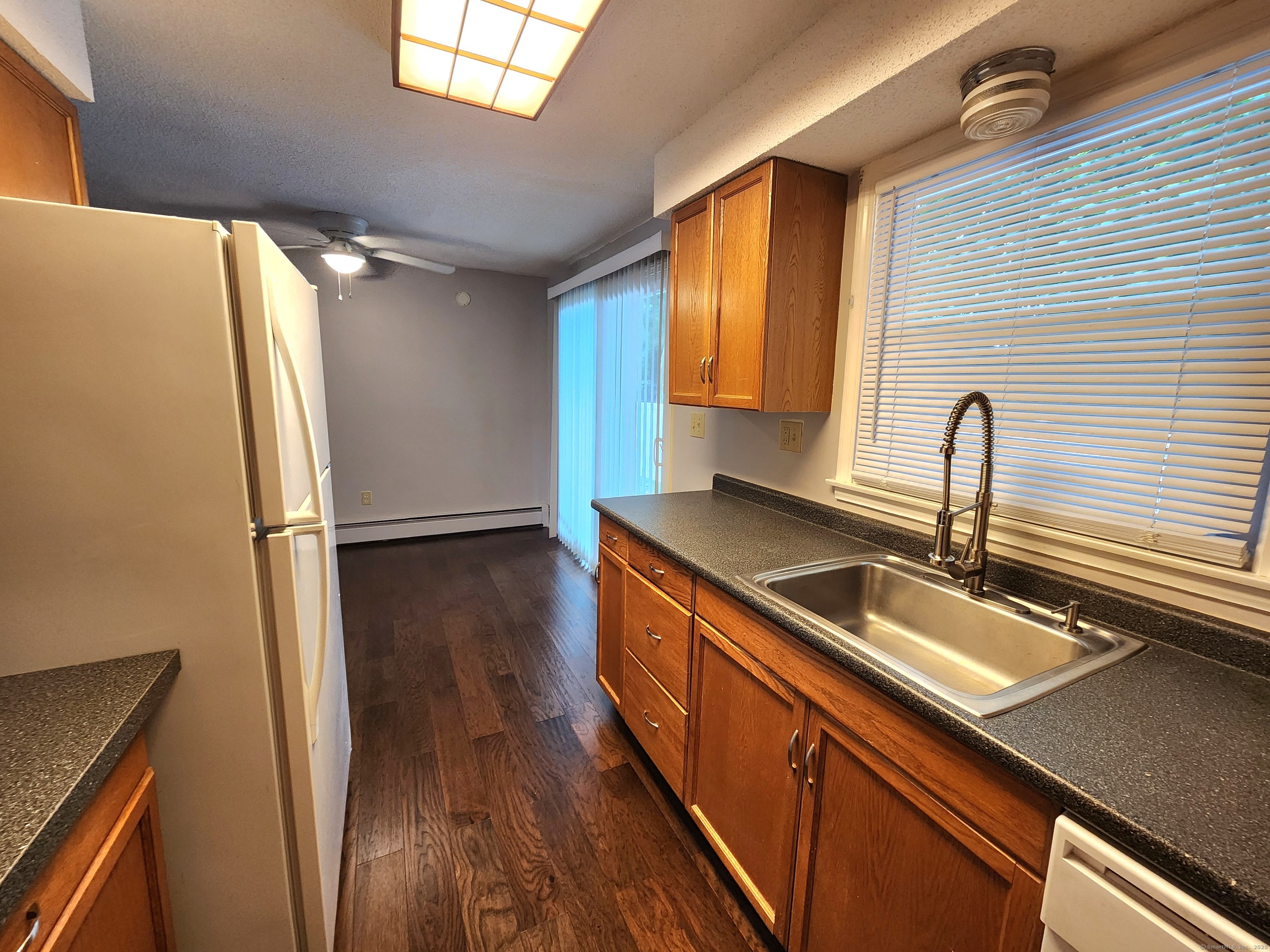 617 Center Street, Unit D Manchester, CT 06040 - Photo 11 of 18 a kitchen with stainless steel appliances granite countertop a sink a refrigerator and wooden floor