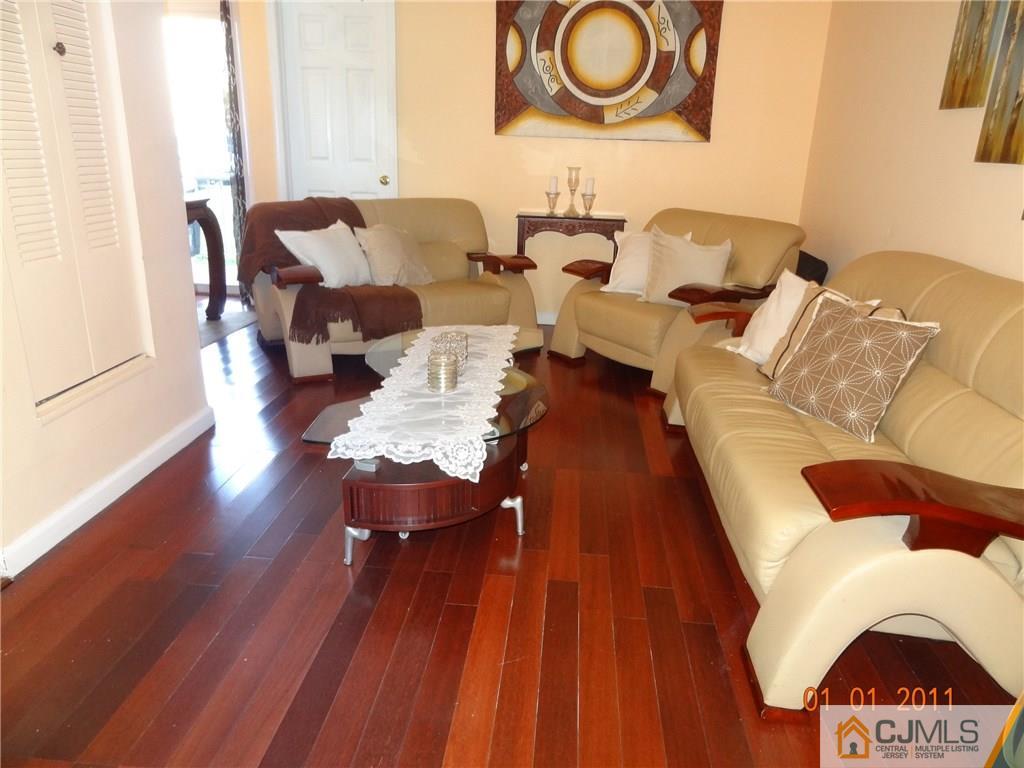 1019 Edpas Road, Unit 1019 New Brunswick, NJ 08901 - Photo 2 of 18 a living room with couches and a coffee table with wooden floor