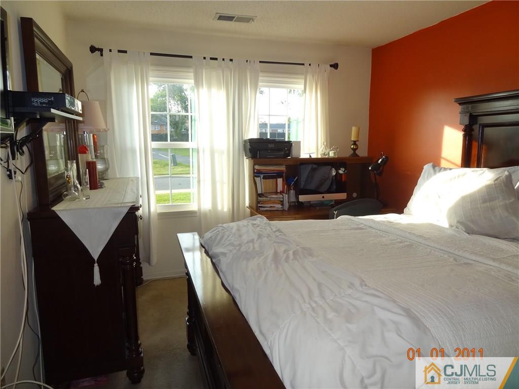 1019 Edpas Road, Unit 1019 New Brunswick, NJ 08901 - Photo 14 of 18 a bedroom with a bed window and a mirror